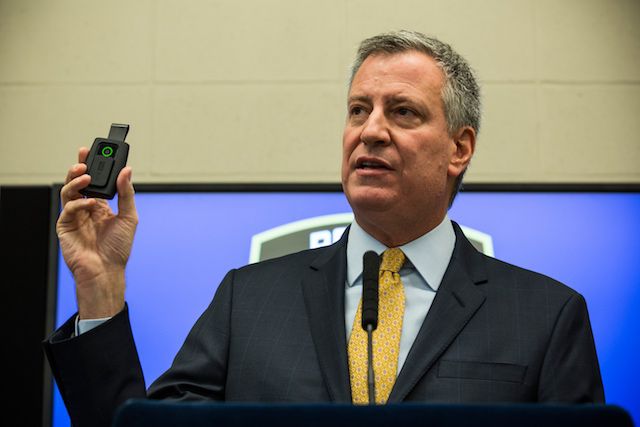 Mayor de Blasio, holding up a body camera that he had to pay for, like some kinda sucker.